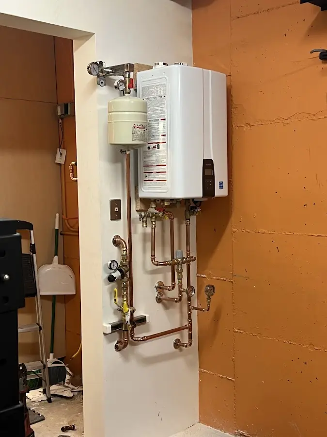 Plumbing technician inspecting water heater connections in Gamewell